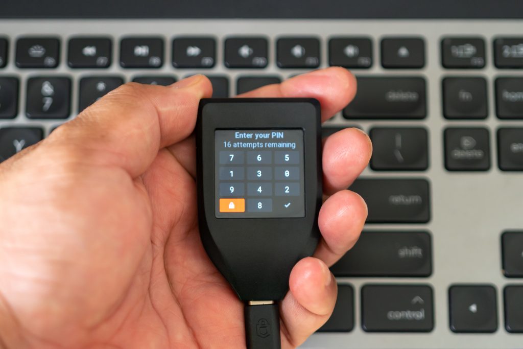 Holding hardware wallet on hand and typing pin code