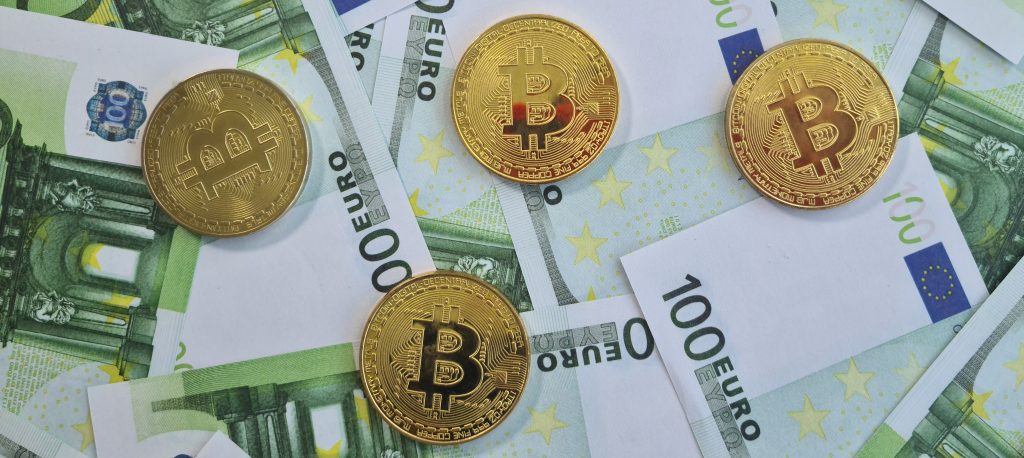 Cryptocurrency bitcoin gold coins on 100 euro banknotes. Bitcoin blockchain cryptocurrency