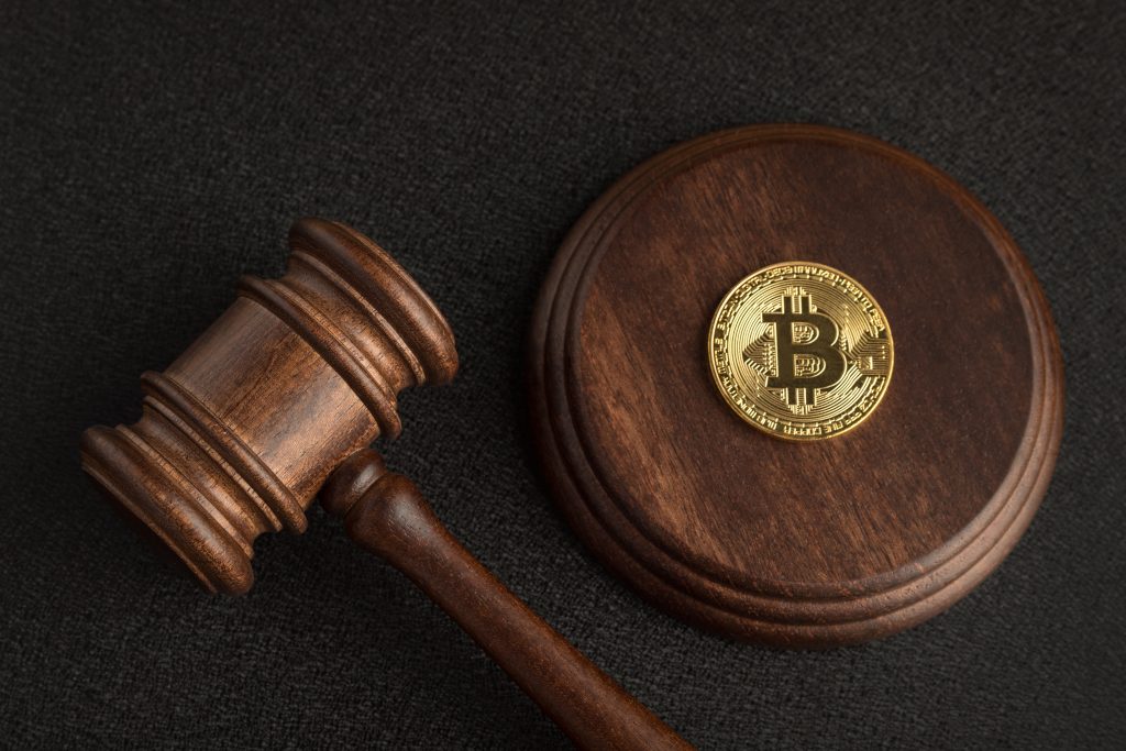 Judge gavel and bitcoin. Cryptocurrency legislation. Bitcoin ban. Violation of law.