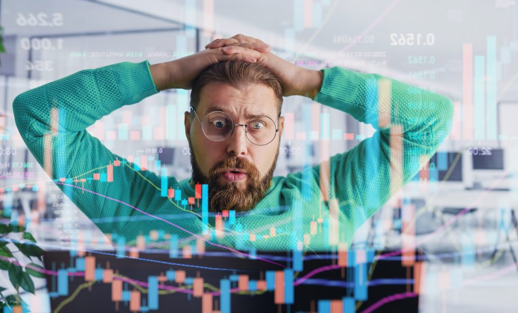 Hombre caucásico barbudo que trabaja en la computadora portátil en la oficina con holograma brillante en la oficina. Sorprendido Crypto Trader sentimiento FUD Monitoreo de datos de datos y gráficos.