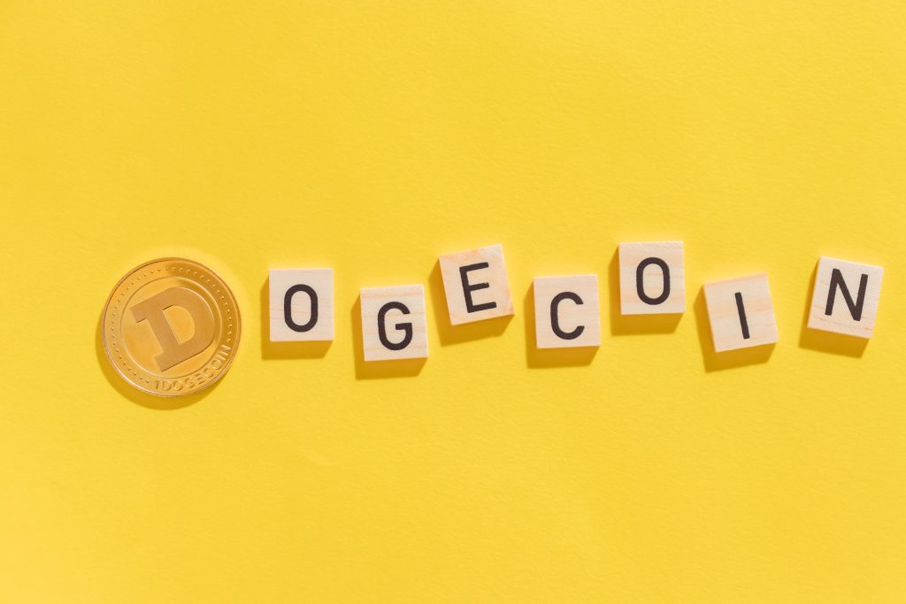 Cryptocurrency Doge with letters on yellow background with hard shadows top view in close-up