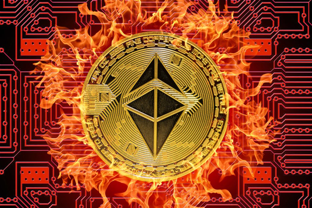 burning golden valueable single ether coin from ethereum crypto currency with a red board in the background middle view. coin burn
