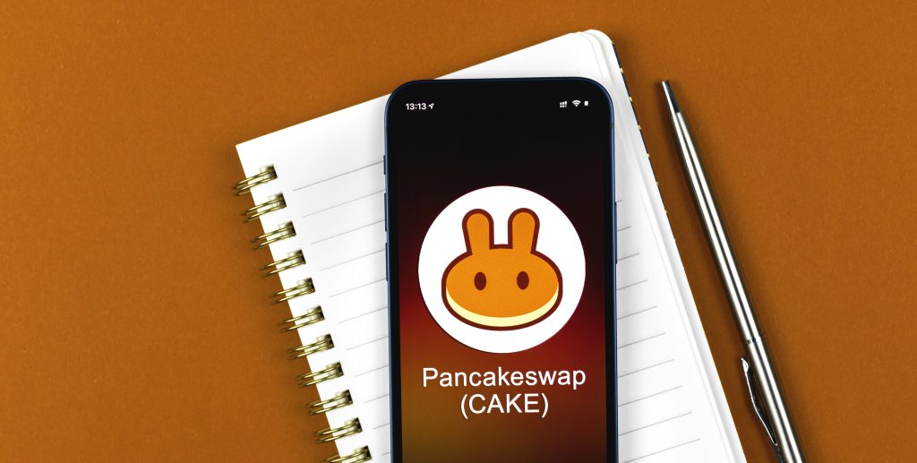 Pancakeswap symbol. Trade with cryptocurrency, digital and virtual money, banking with mobile phone concept. Business workspace, banner, table top view